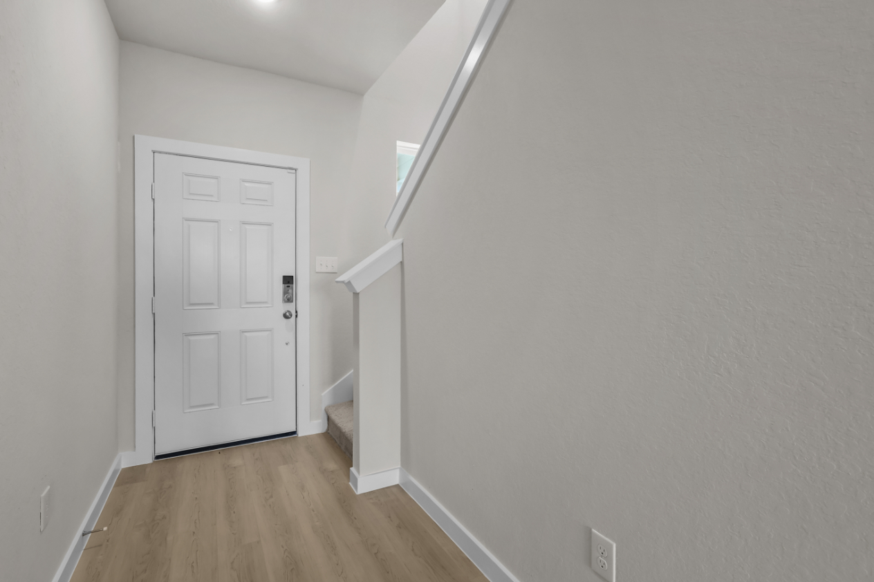 A room with a white door and a white wall.