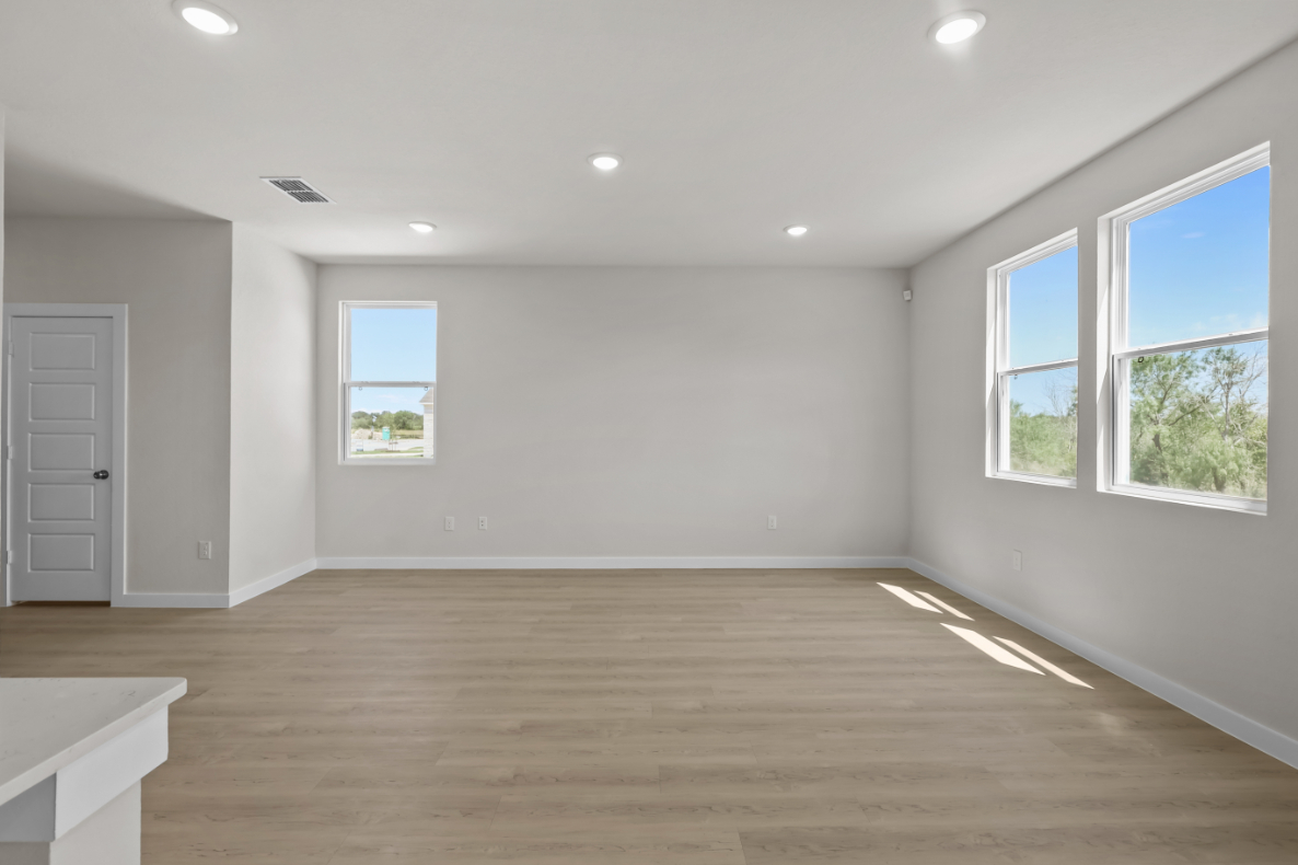 A room with windows and a wood floor.
