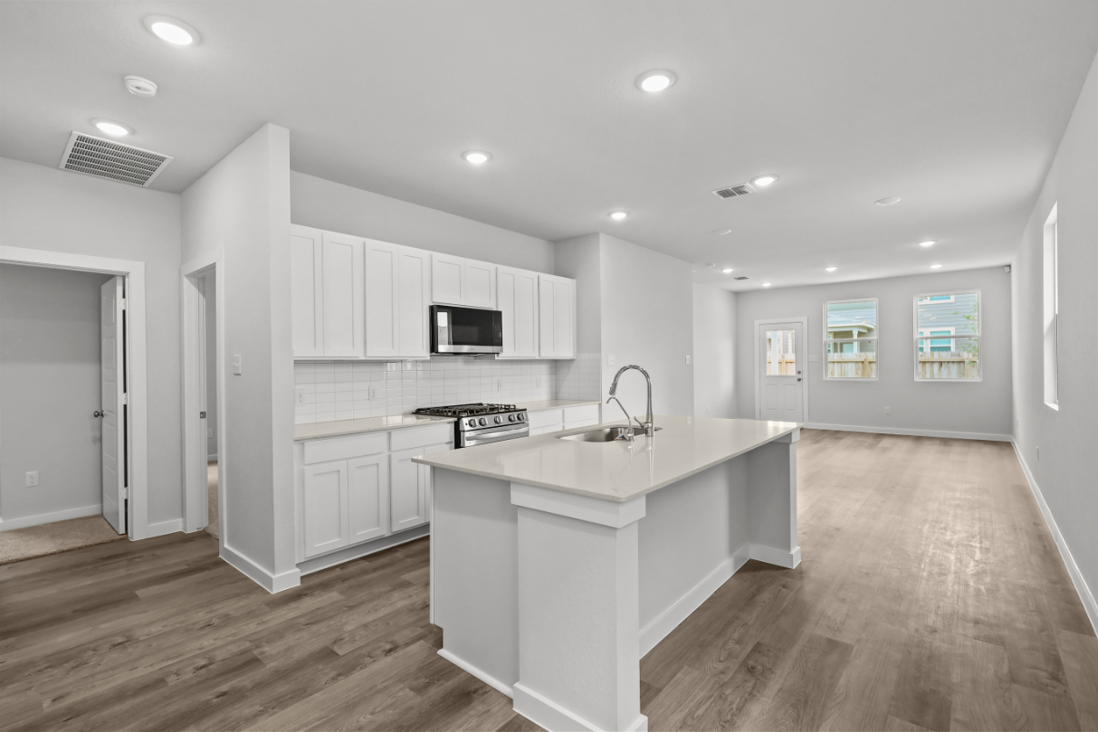 A kitchen with white cabinets.