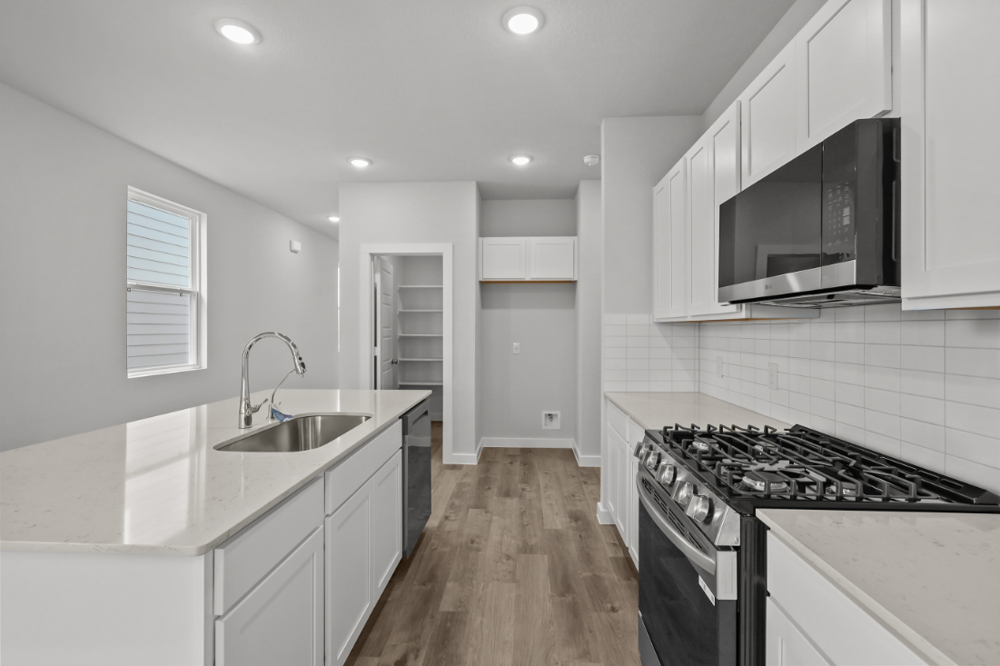 A kitchen with white cabinets.