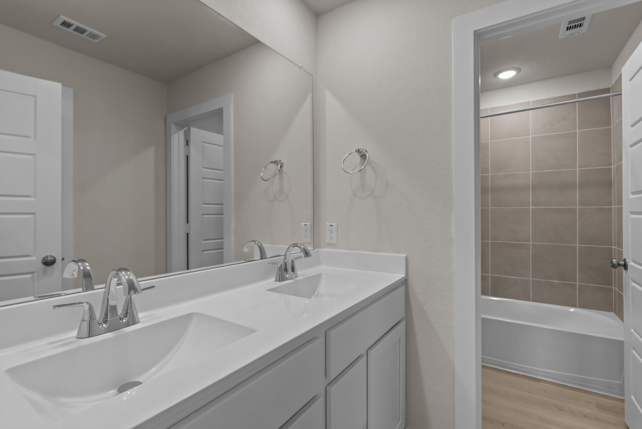 A bathroom with a tub sink and a shower unit.