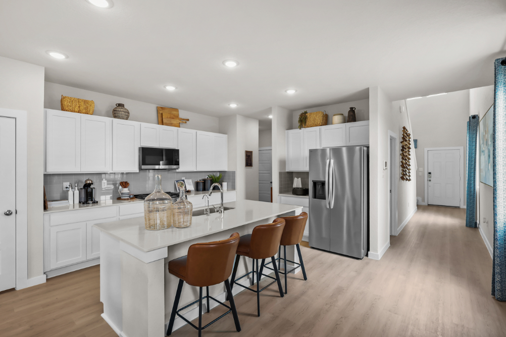 A kitchen with white cabinets.