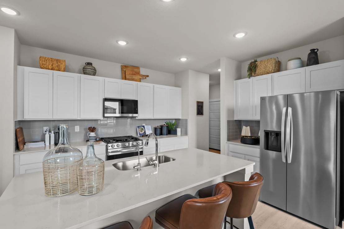A kitchen with white cabinets.