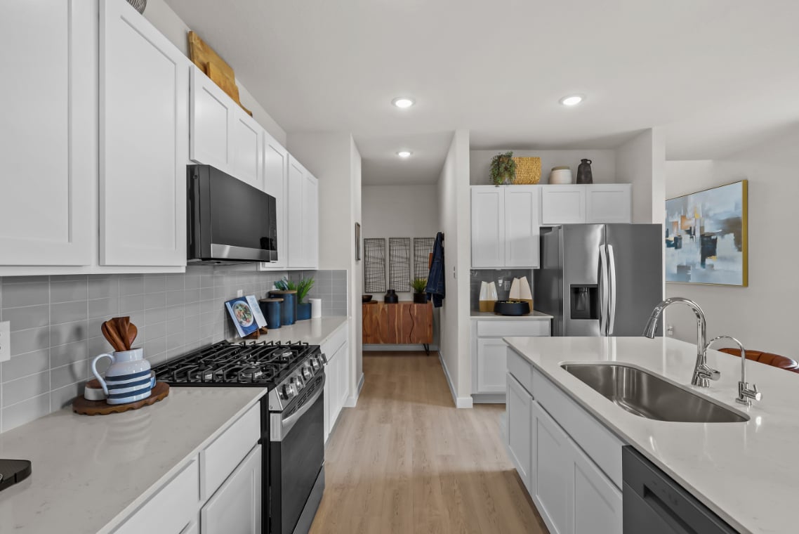 A kitchen with white cabinets.
