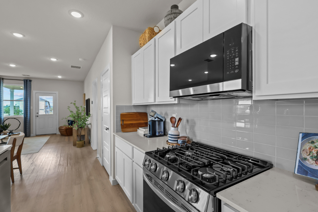 A kitchen with white cabinets.