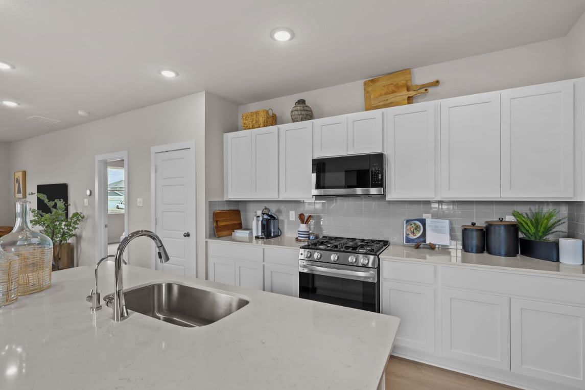 A kitchen with white cabinets.