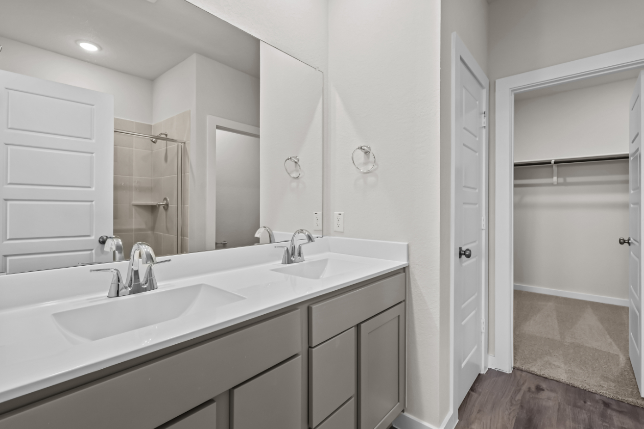 A bathroom with a sink and a shower unit.