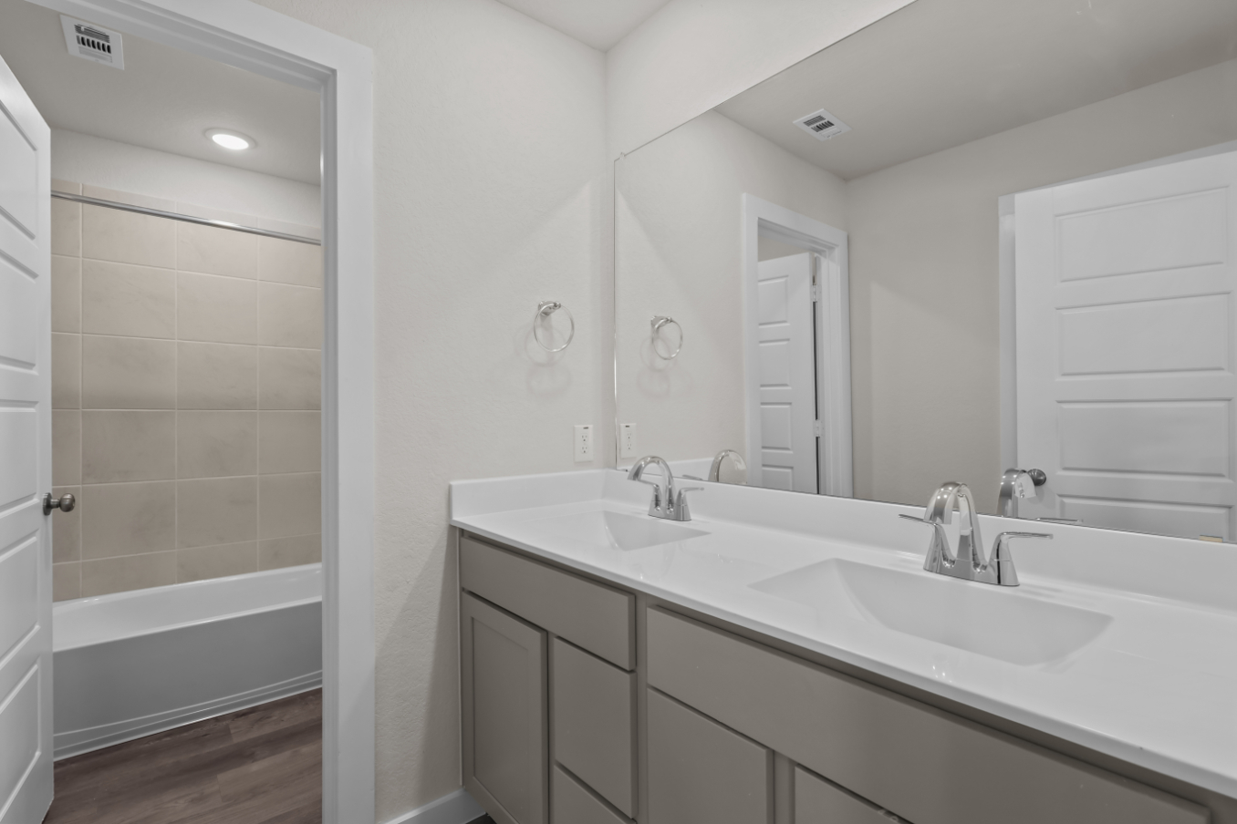 A bathroom with a tub sink and a mirror.