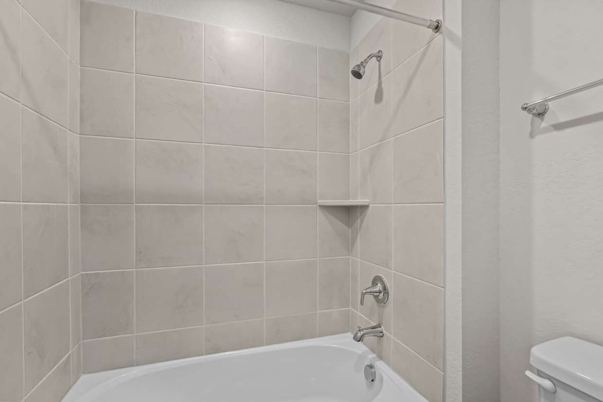 A bathroom with a bathtub and toilet.