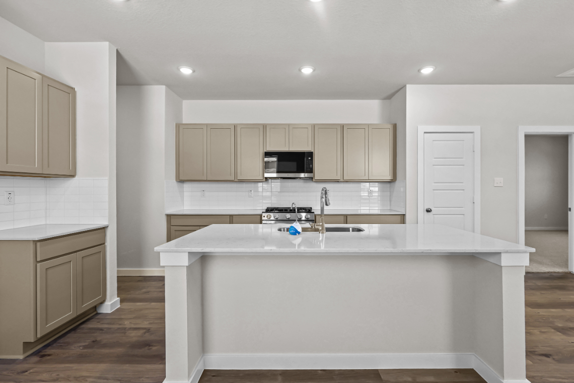 A kitchen with white cabinets.