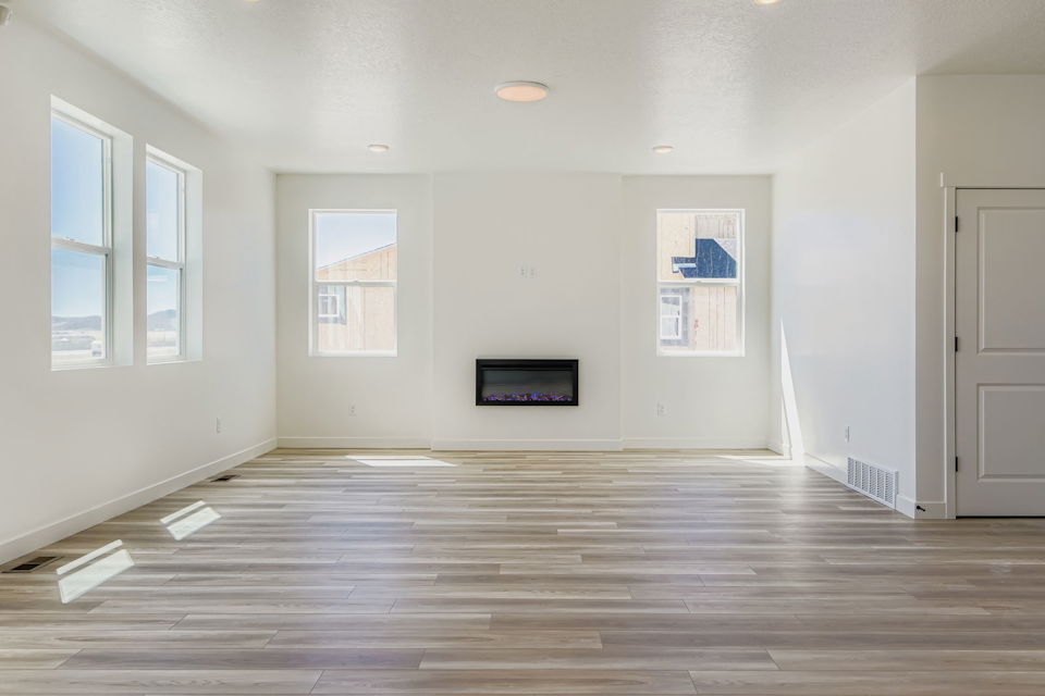 A room with white walls and a television on the wall.