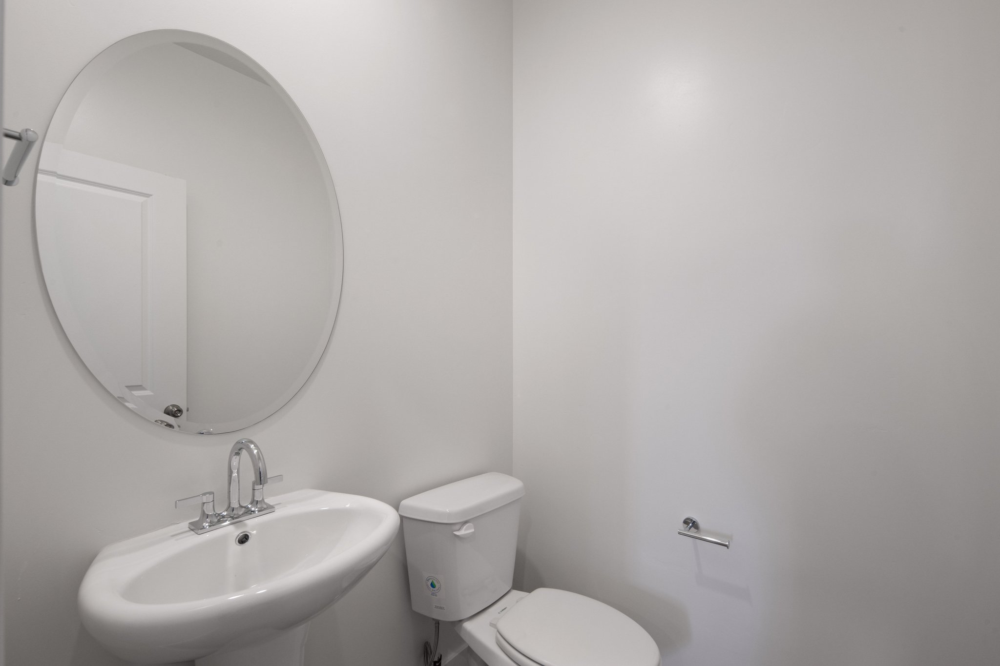 A bathroom with a round mirror.