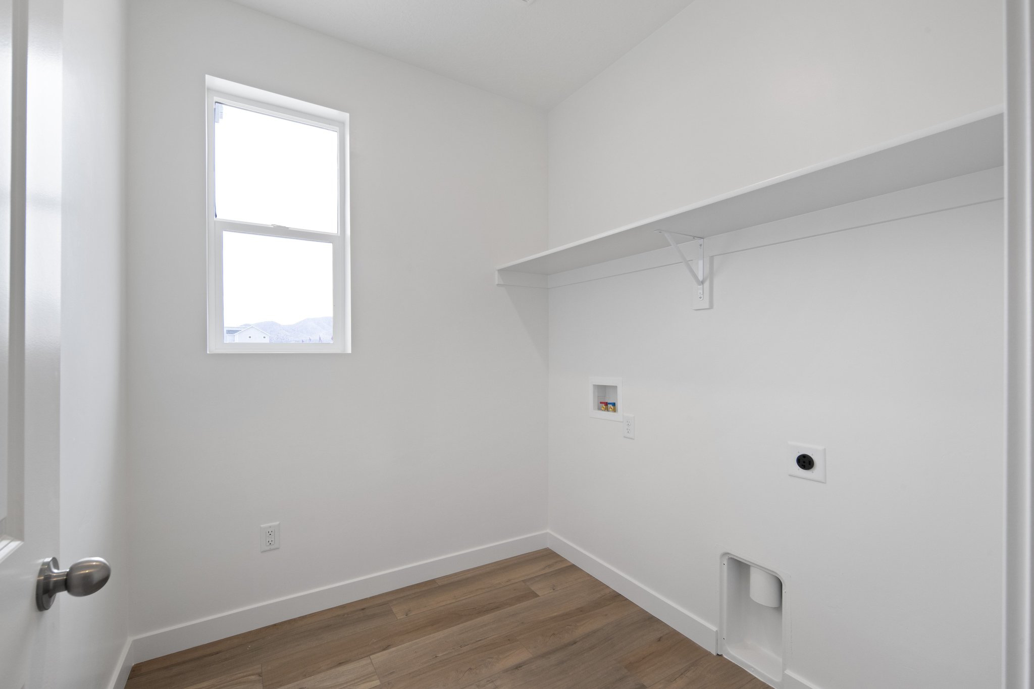 A room with a wood floor and a window.