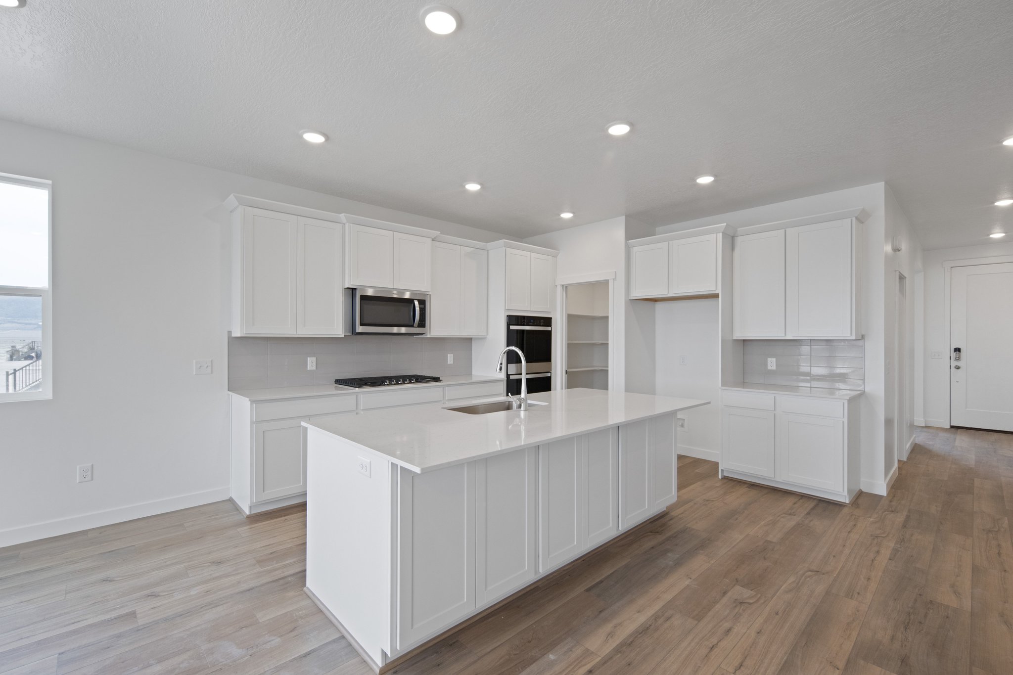 A kitchen with white cabinets.
