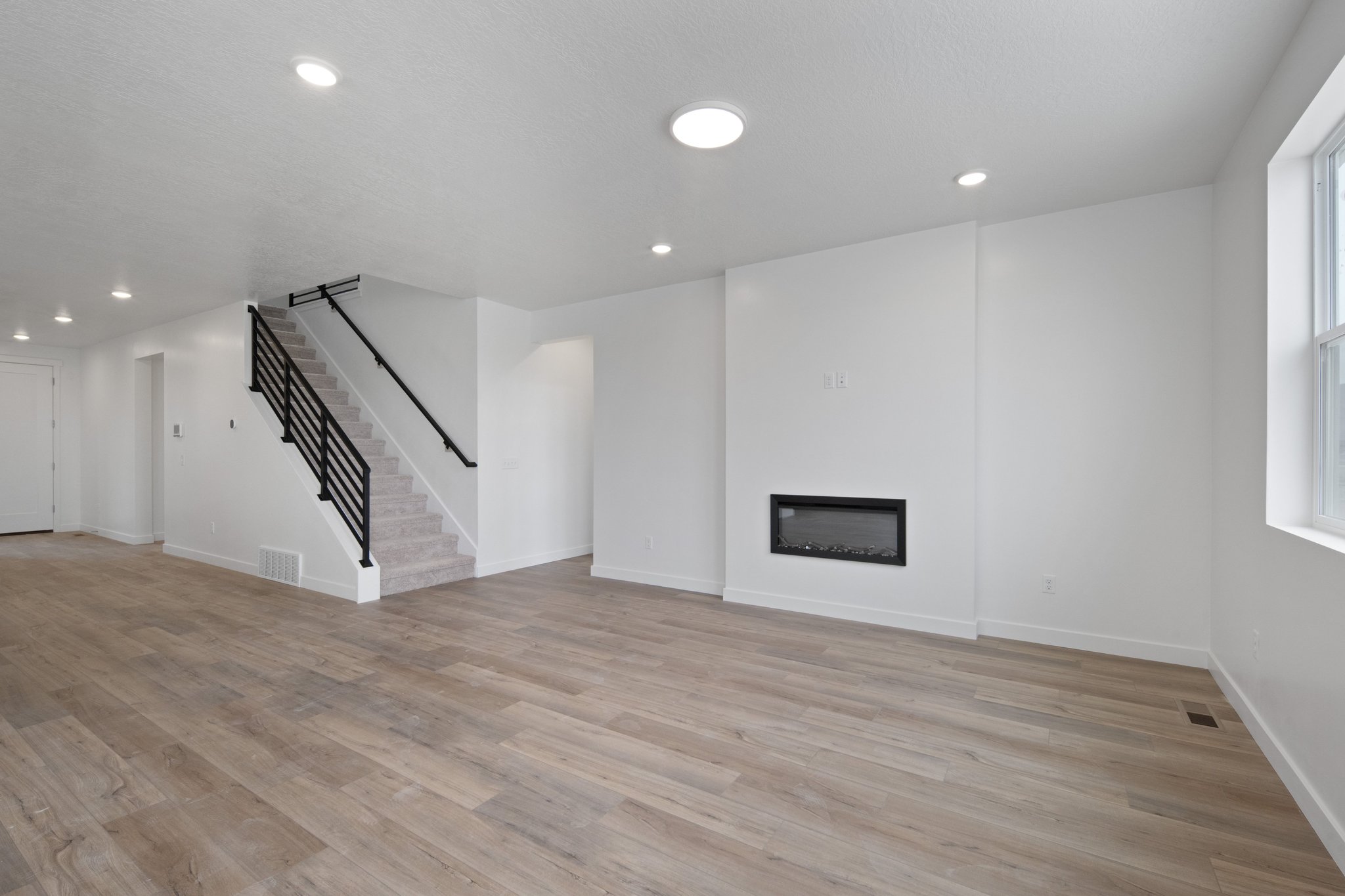 A large empty room with a staircase.