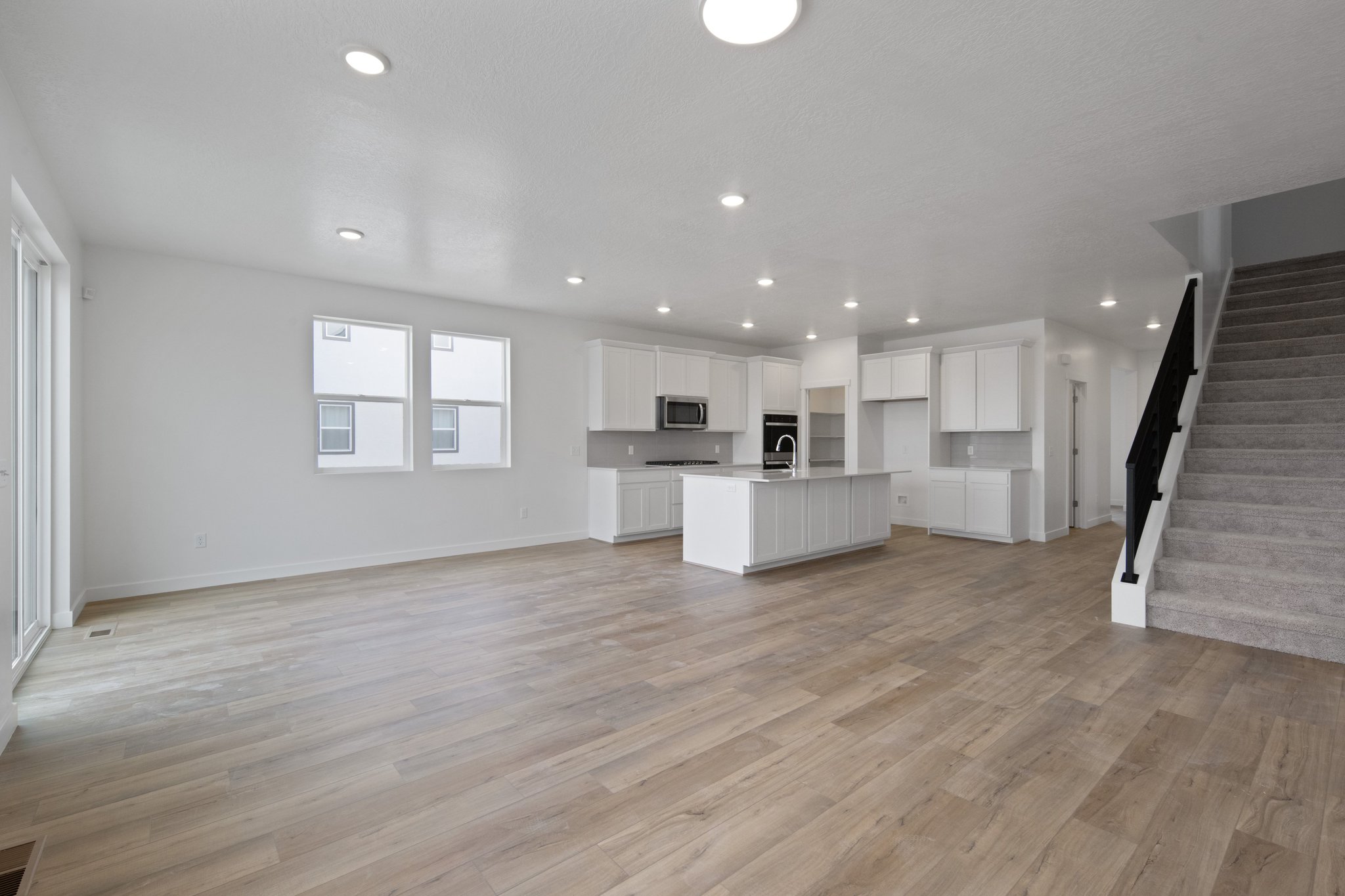 A large empty room with white cabinets.