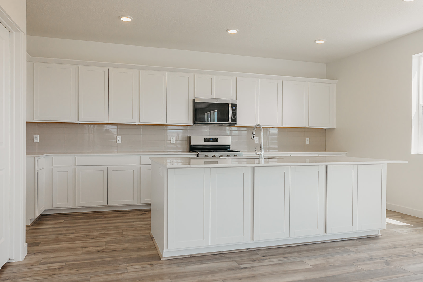 A kitchen with white cabinets.