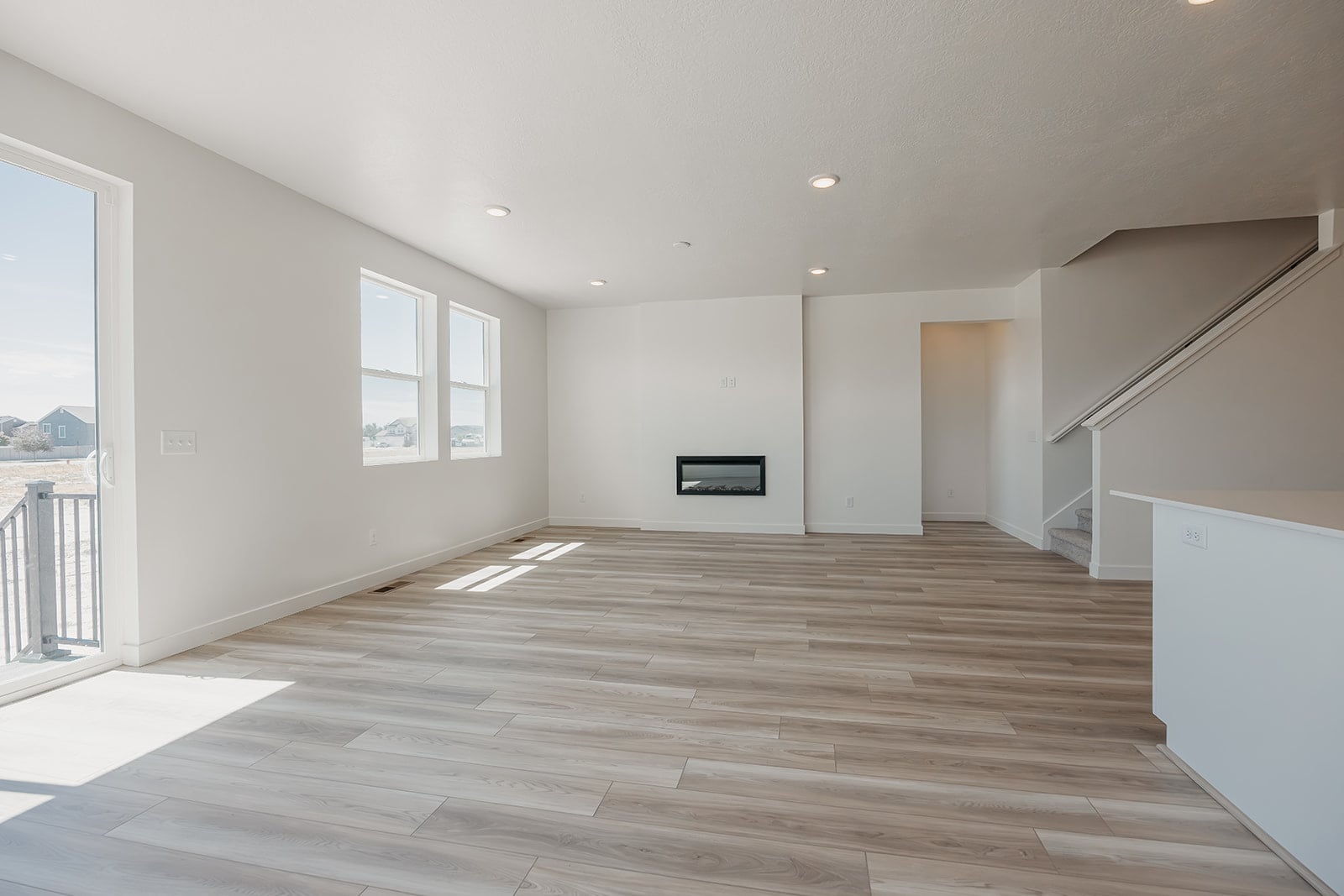 A large empty room with a wood floor and white walls.