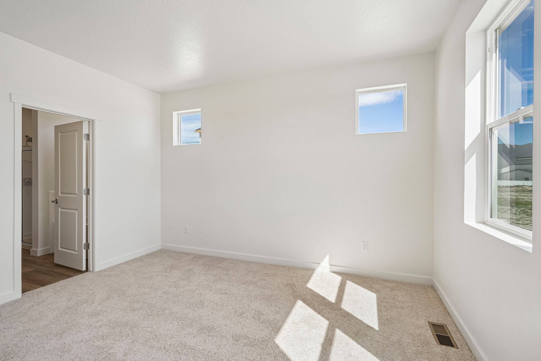 A room with a carpet and windows.
