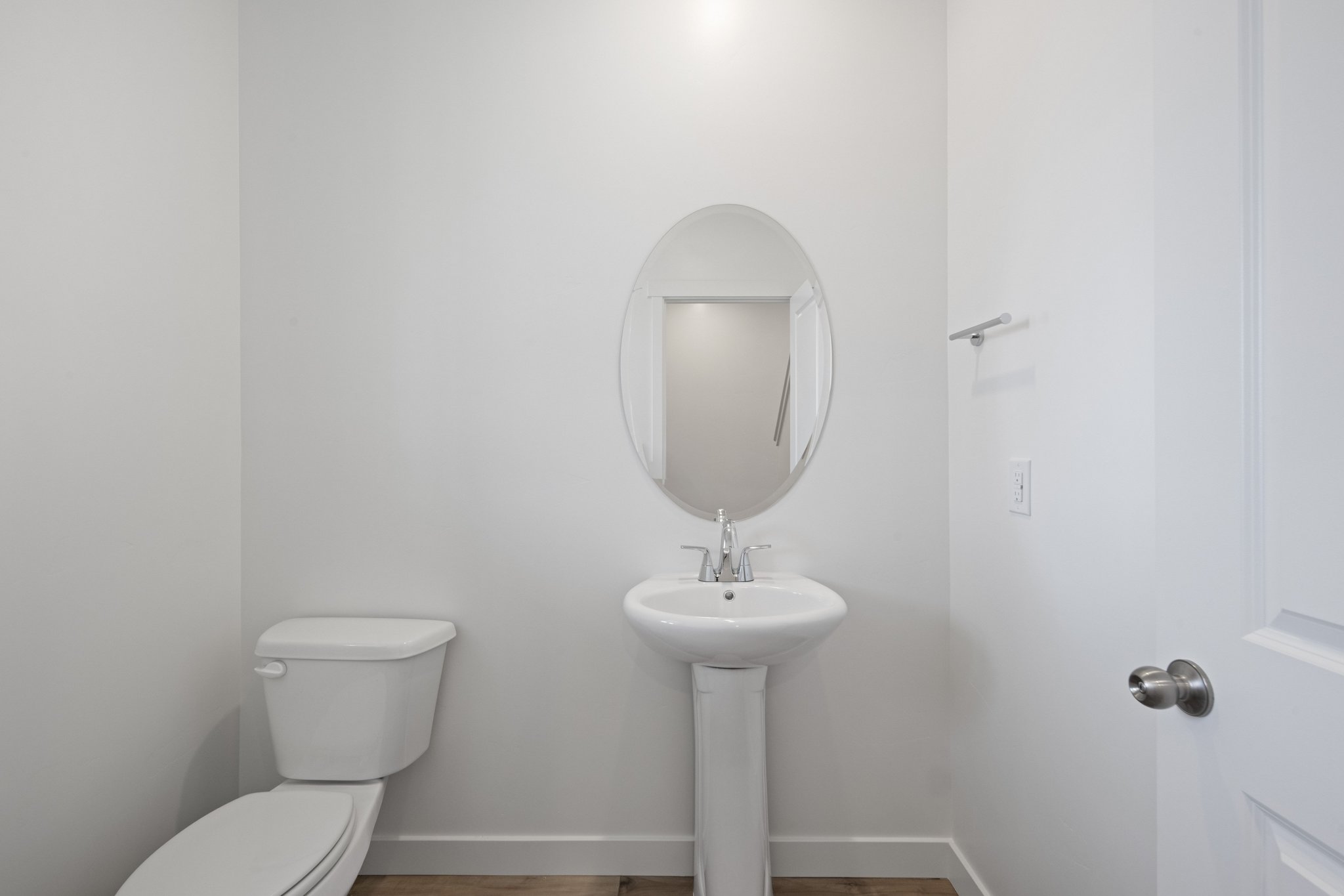 A bathroom with a round mirror.