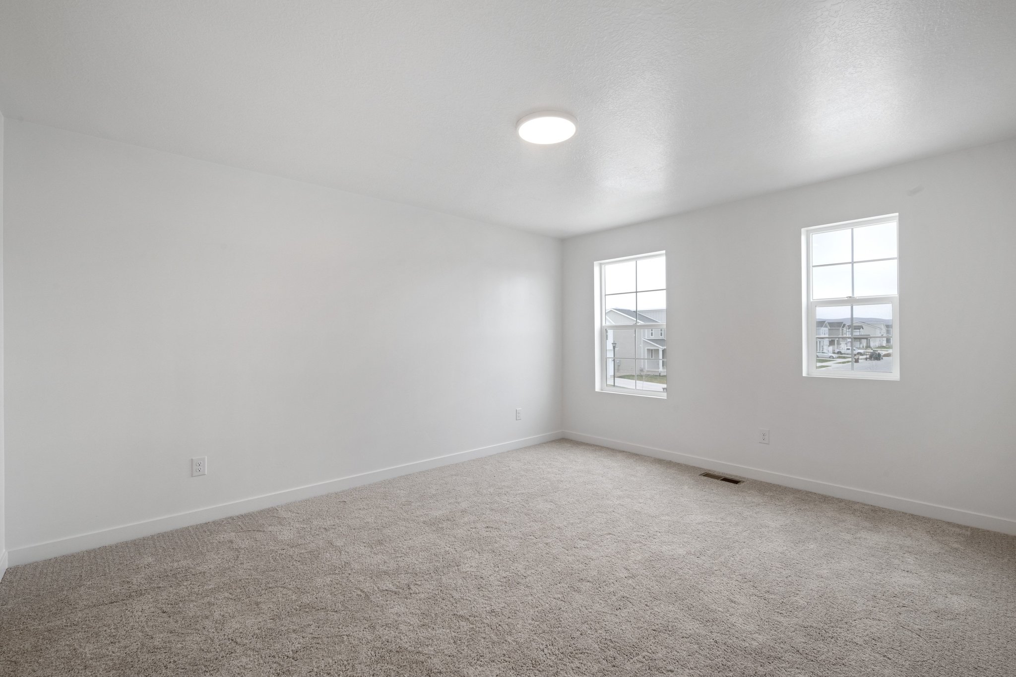 A room with a carpet and windows.