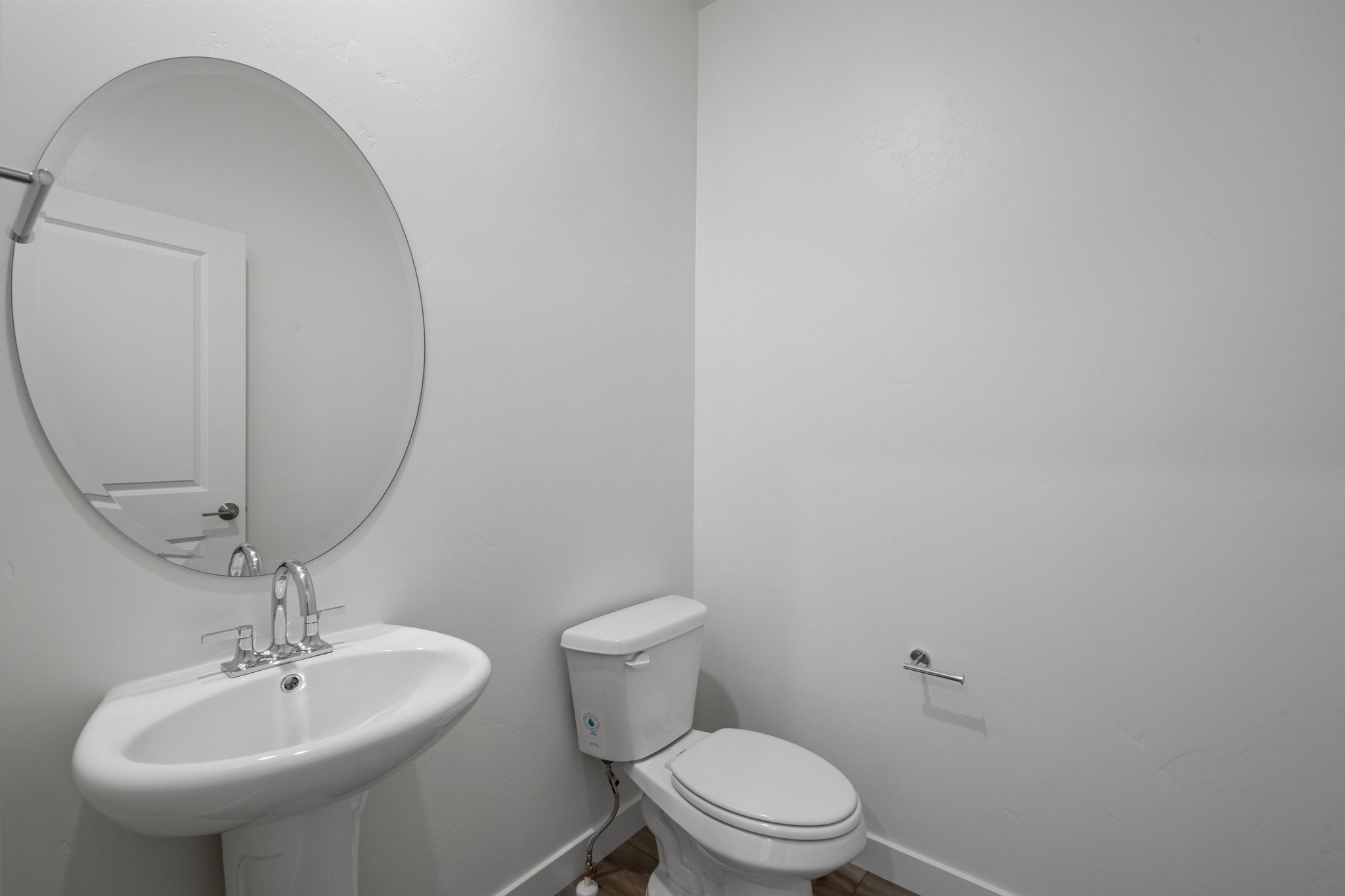A bathroom with a round mirror.