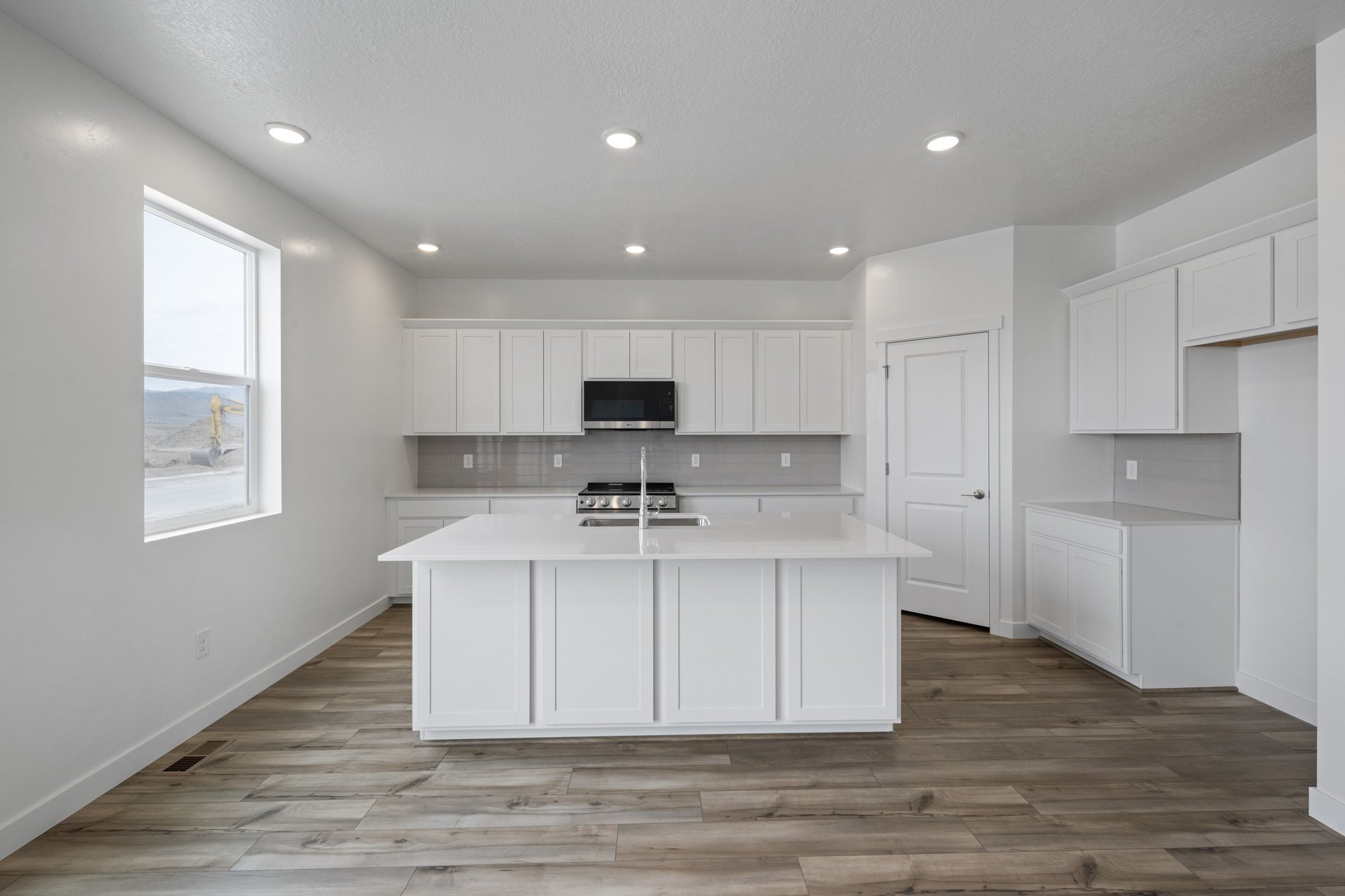A kitchen with white cabinets.