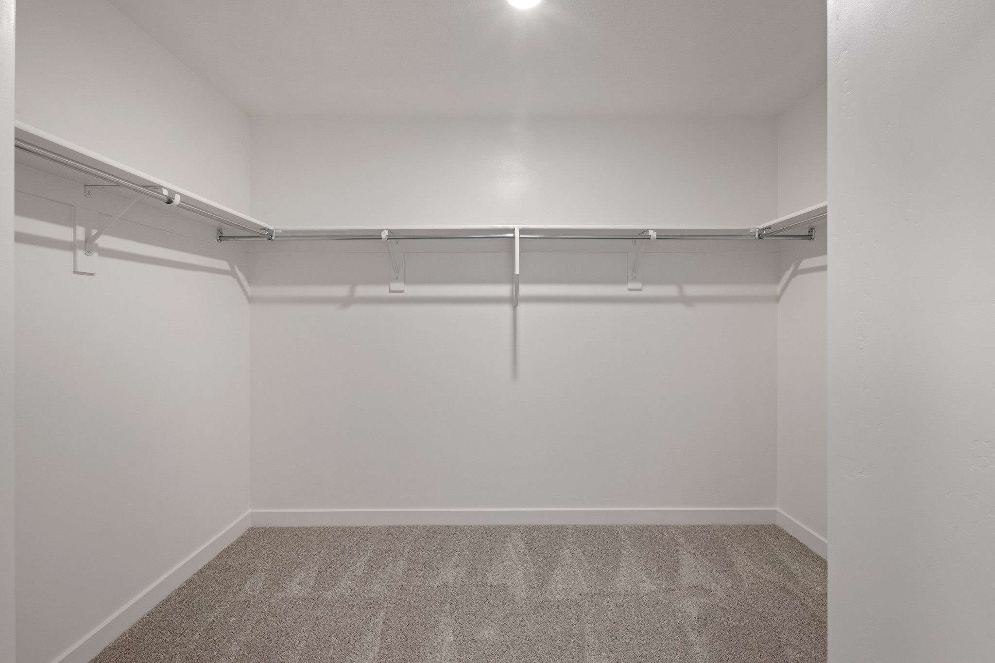 A white wall with a metal railing.