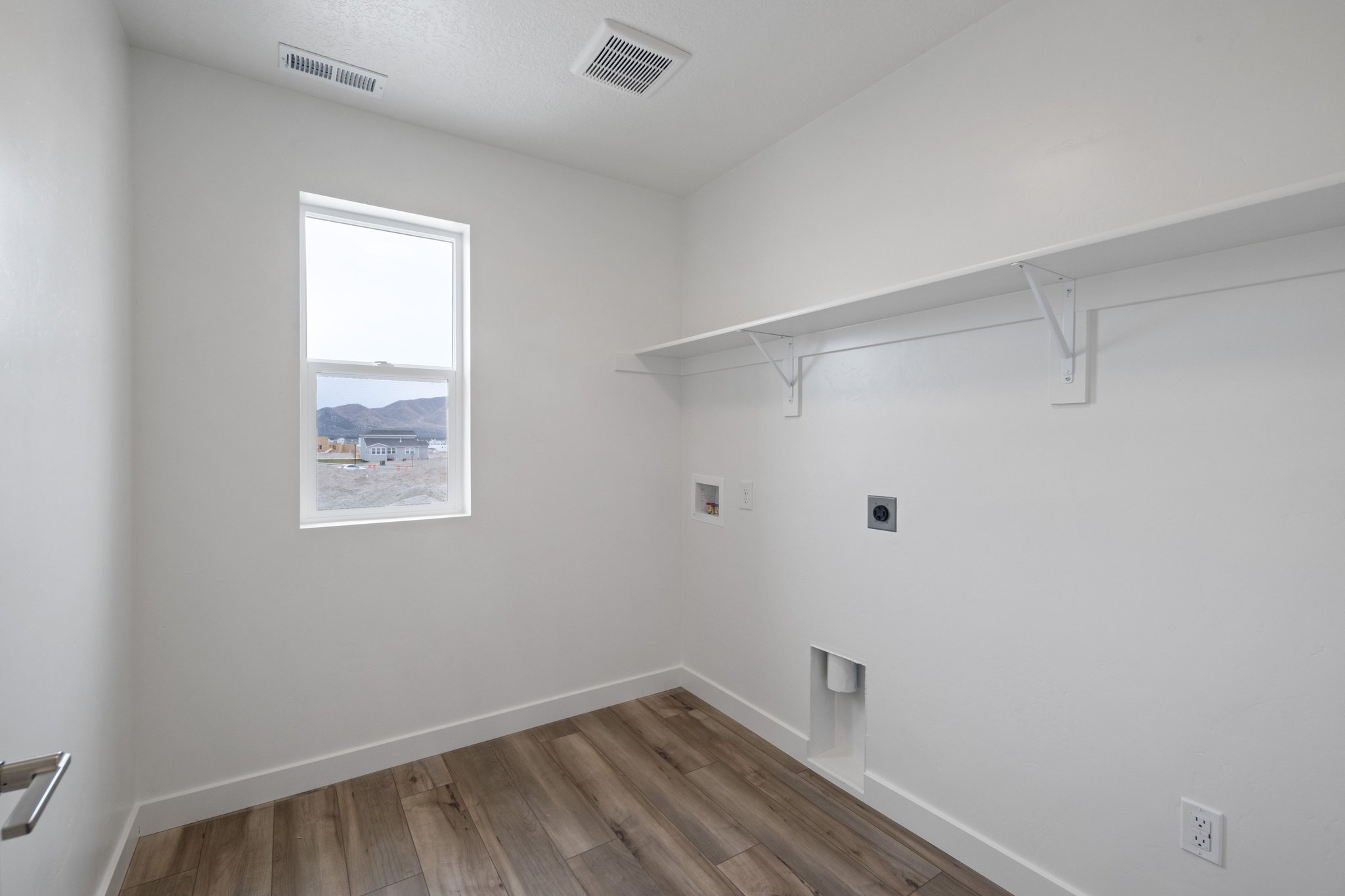 A room with a wood floor and a window.