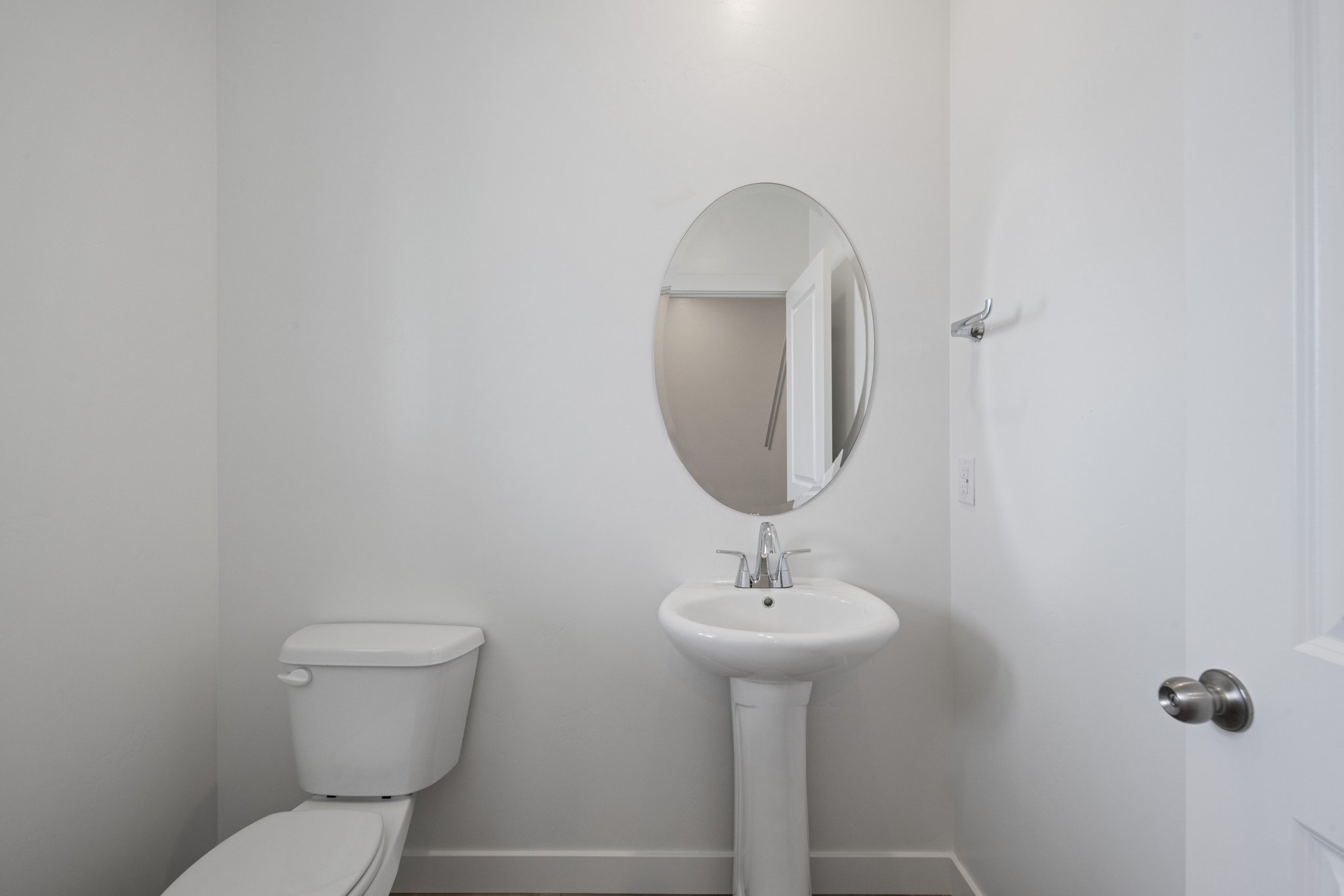 A bathroom with a round mirror.