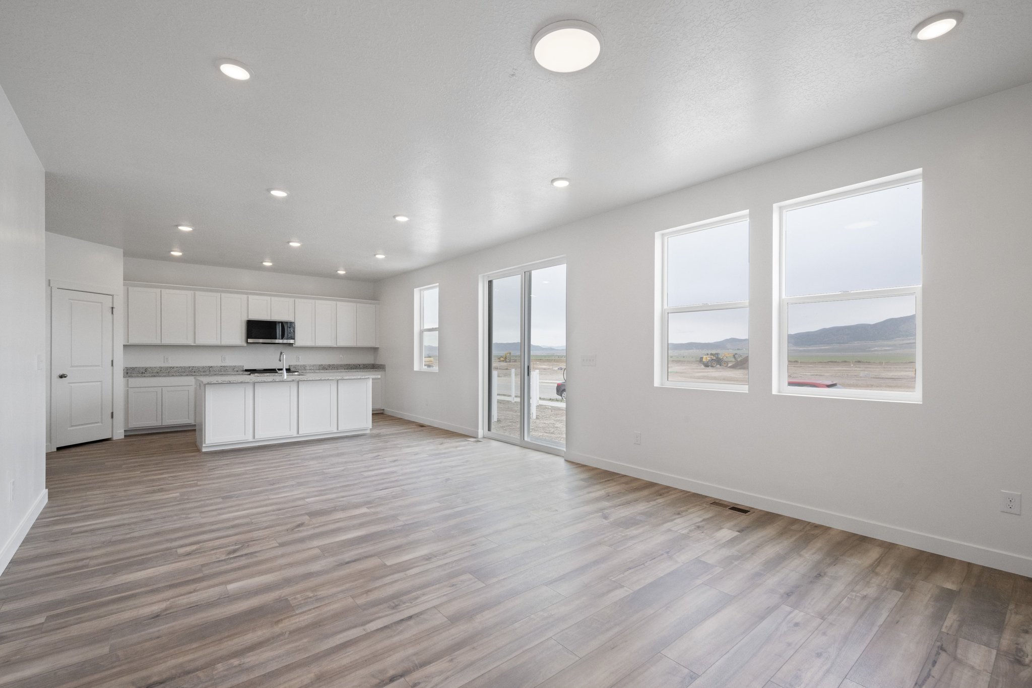 A large empty room with white cabinets.