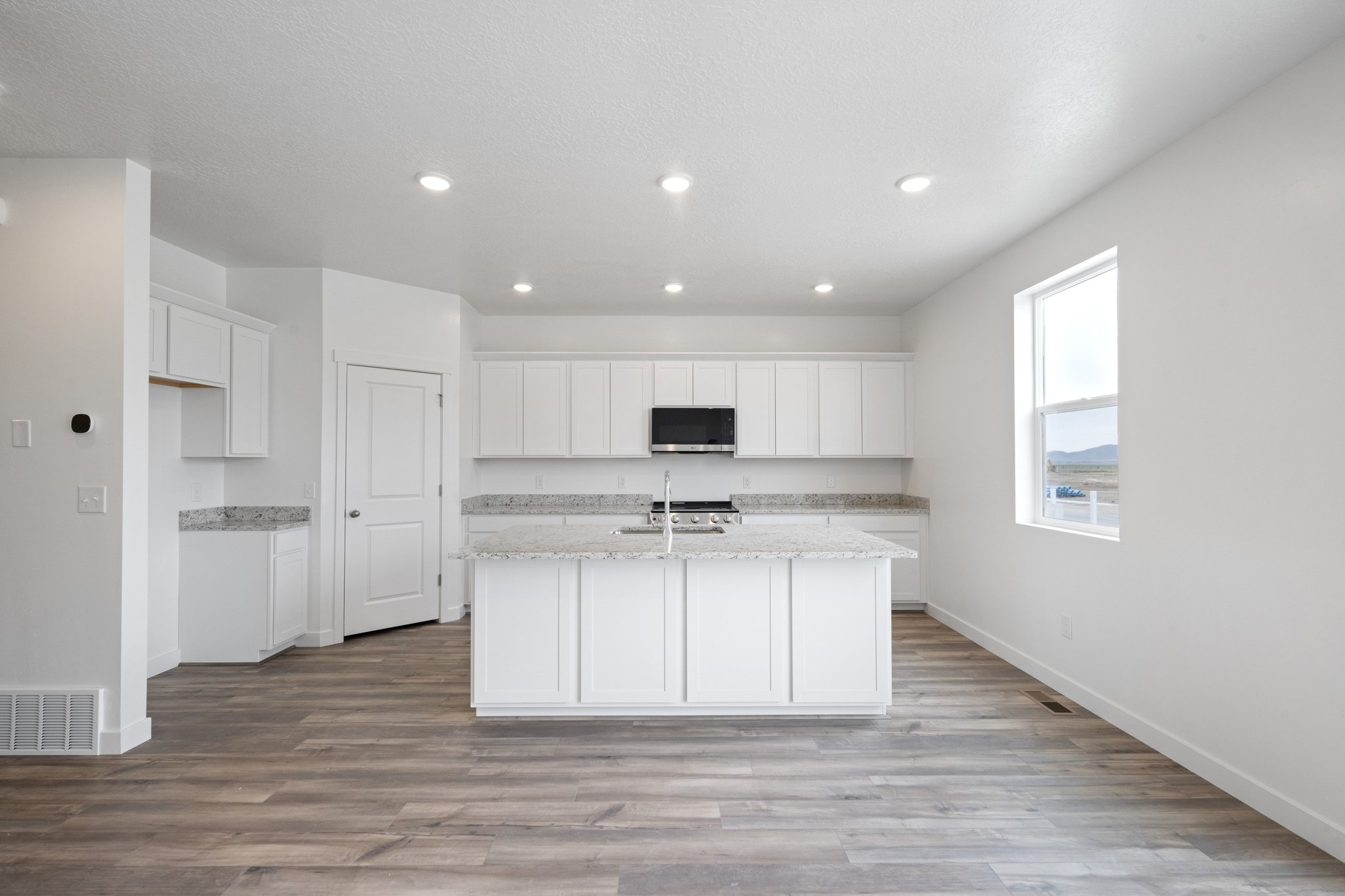 A kitchen with white cabinets.