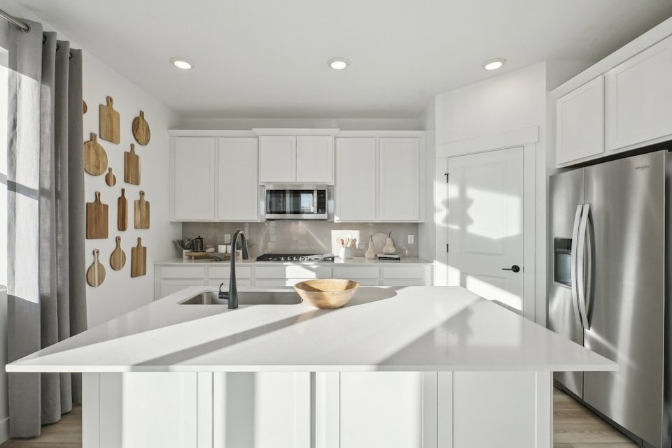 A kitchen with white cabinets.