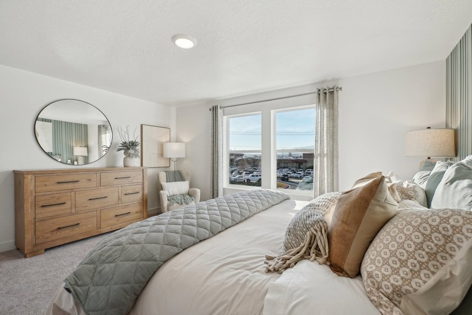 A bedroom with a large window.