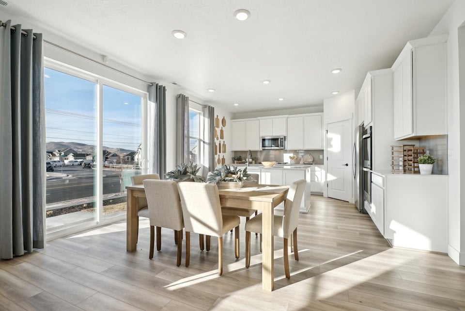 A kitchen with a dining table and chairs.