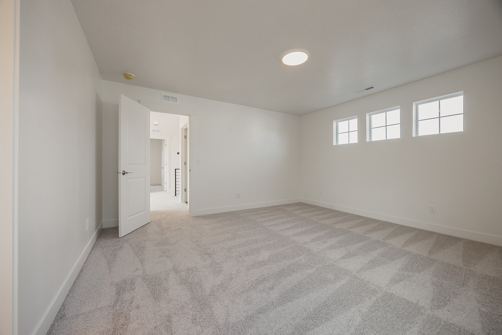 A room with white walls and a carpeted floor.