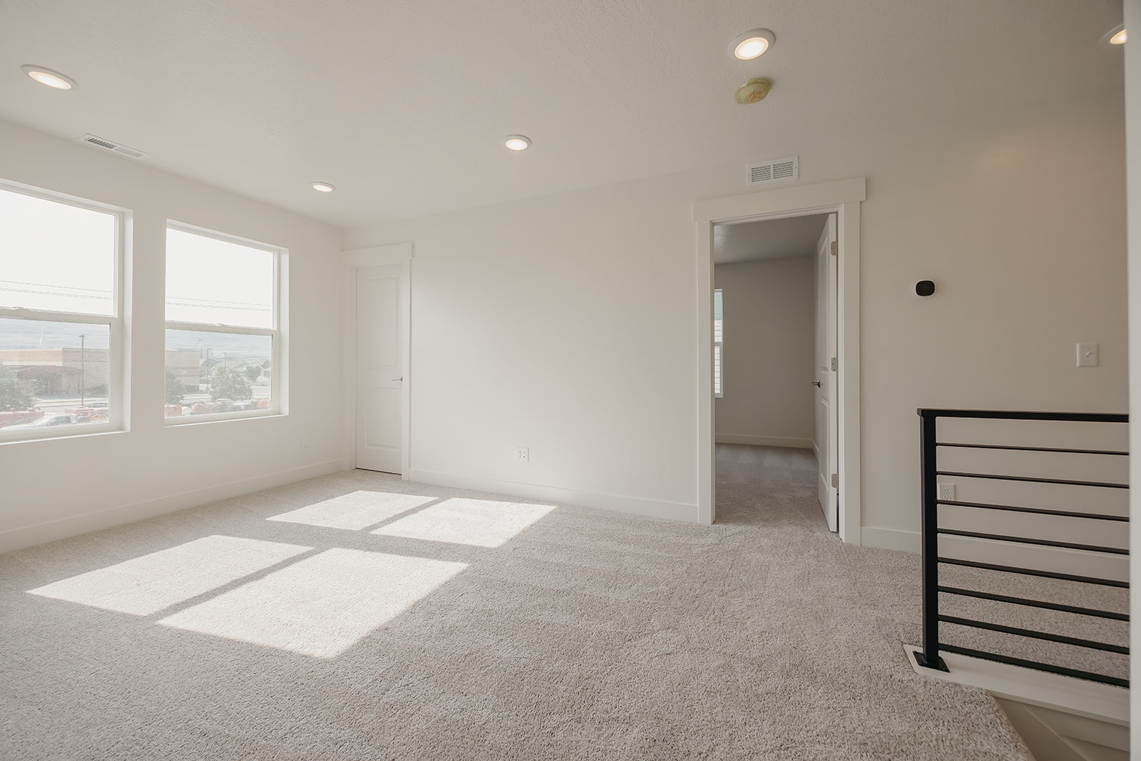 A room with a carpet and a window.