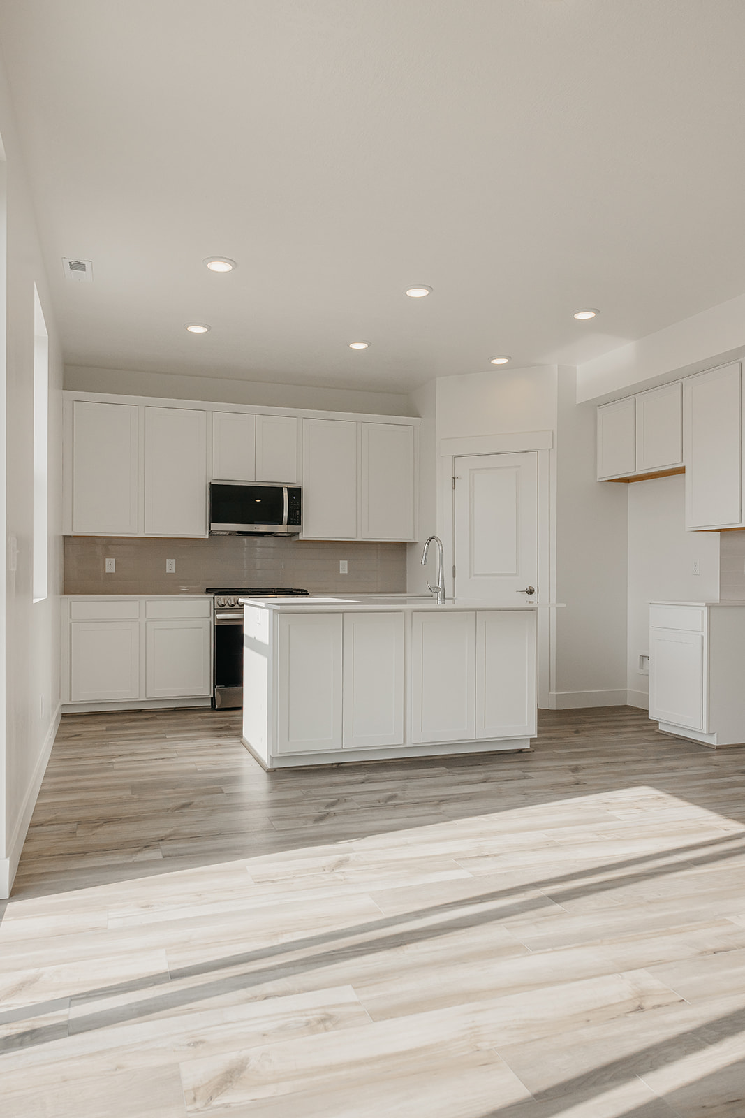 A kitchen with white cabinets.