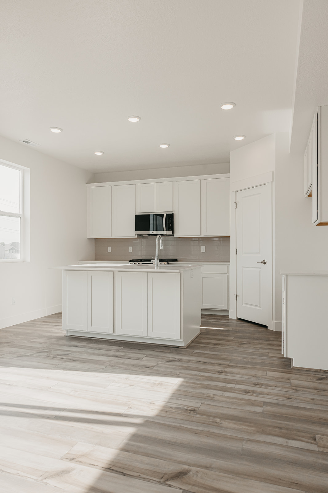 A kitchen with white cabinets.