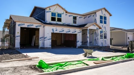 A building with a few green objects in front of it.