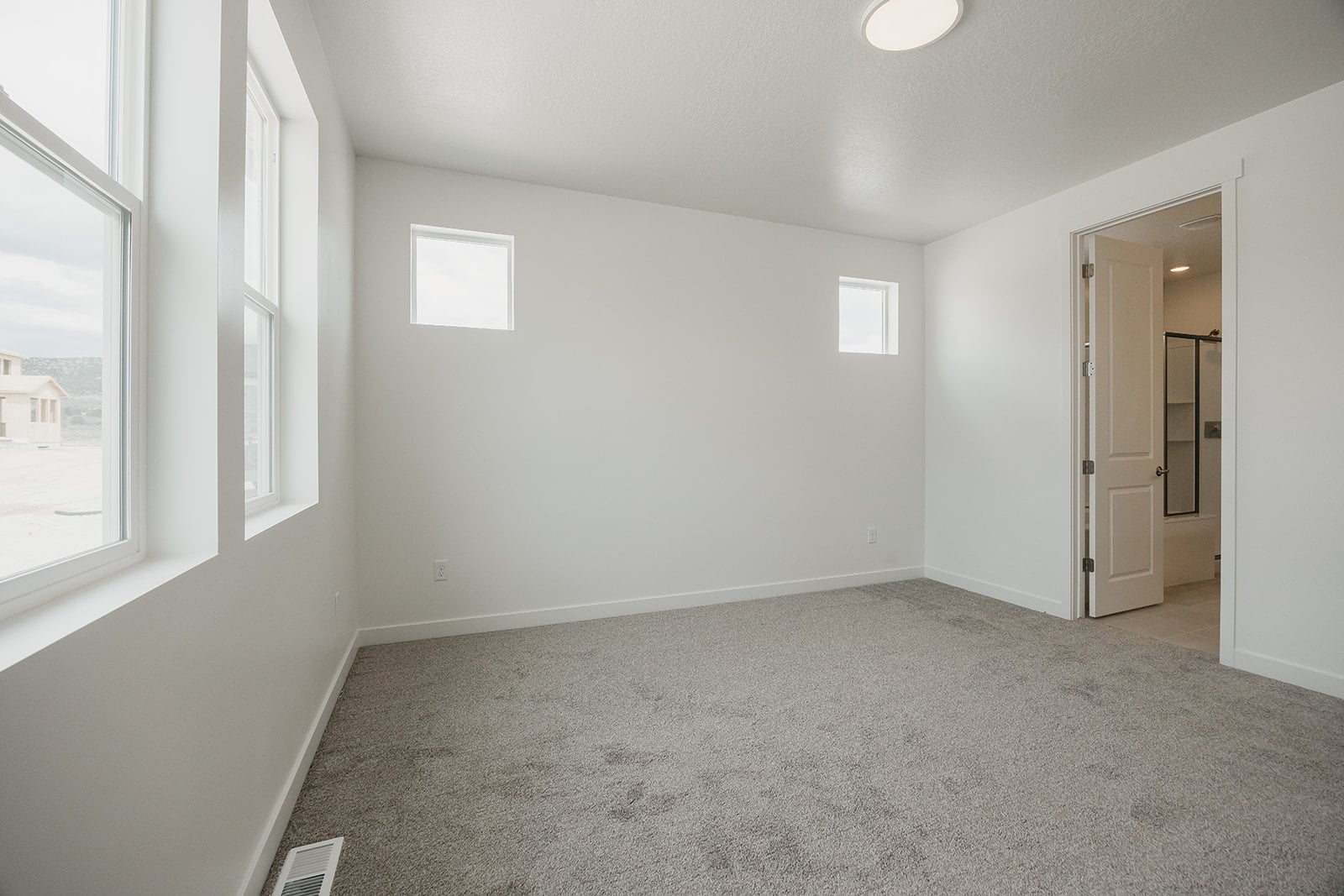 A room with a carpet and a door.
