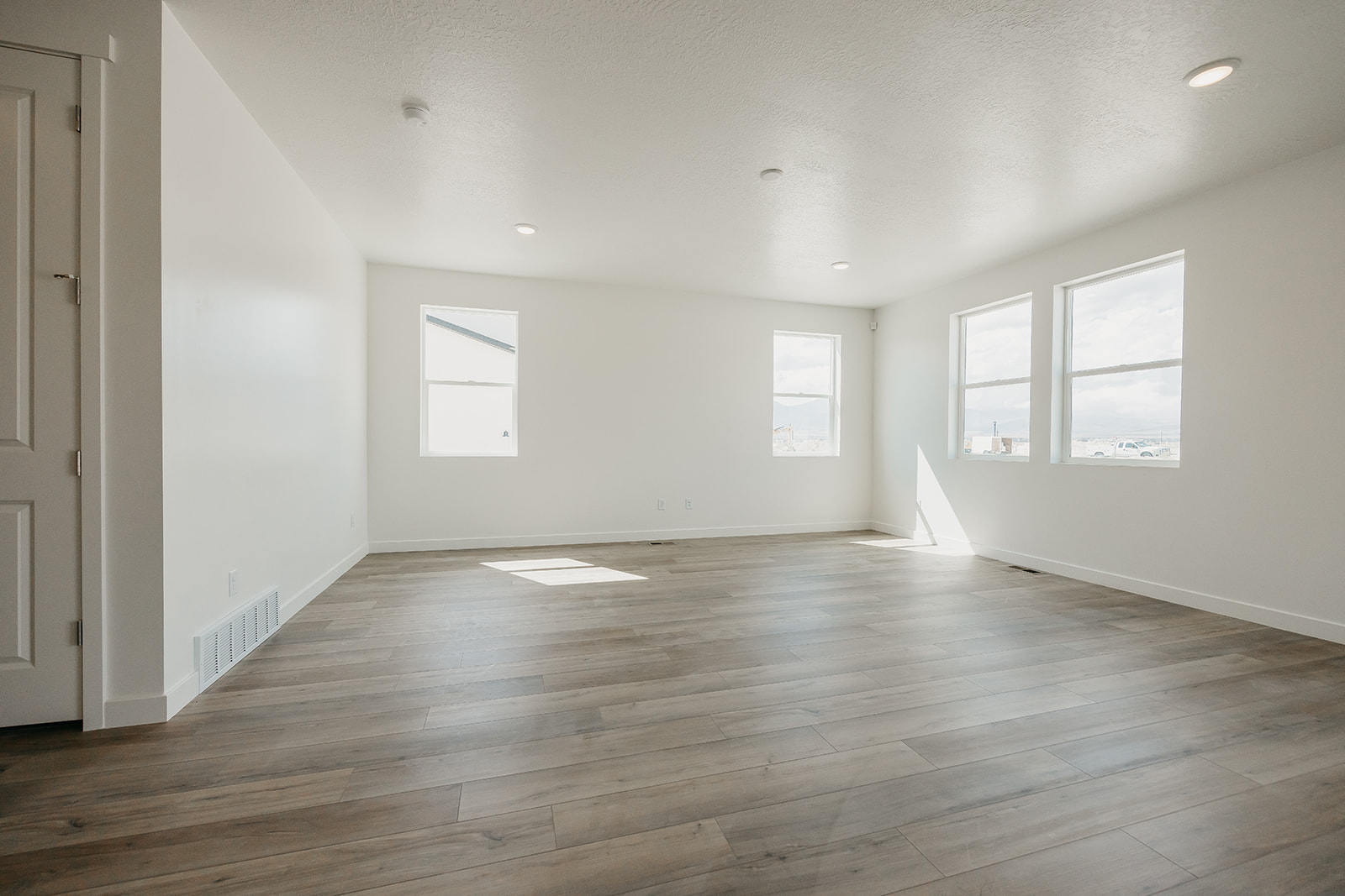 A room with a wood floor and windows.