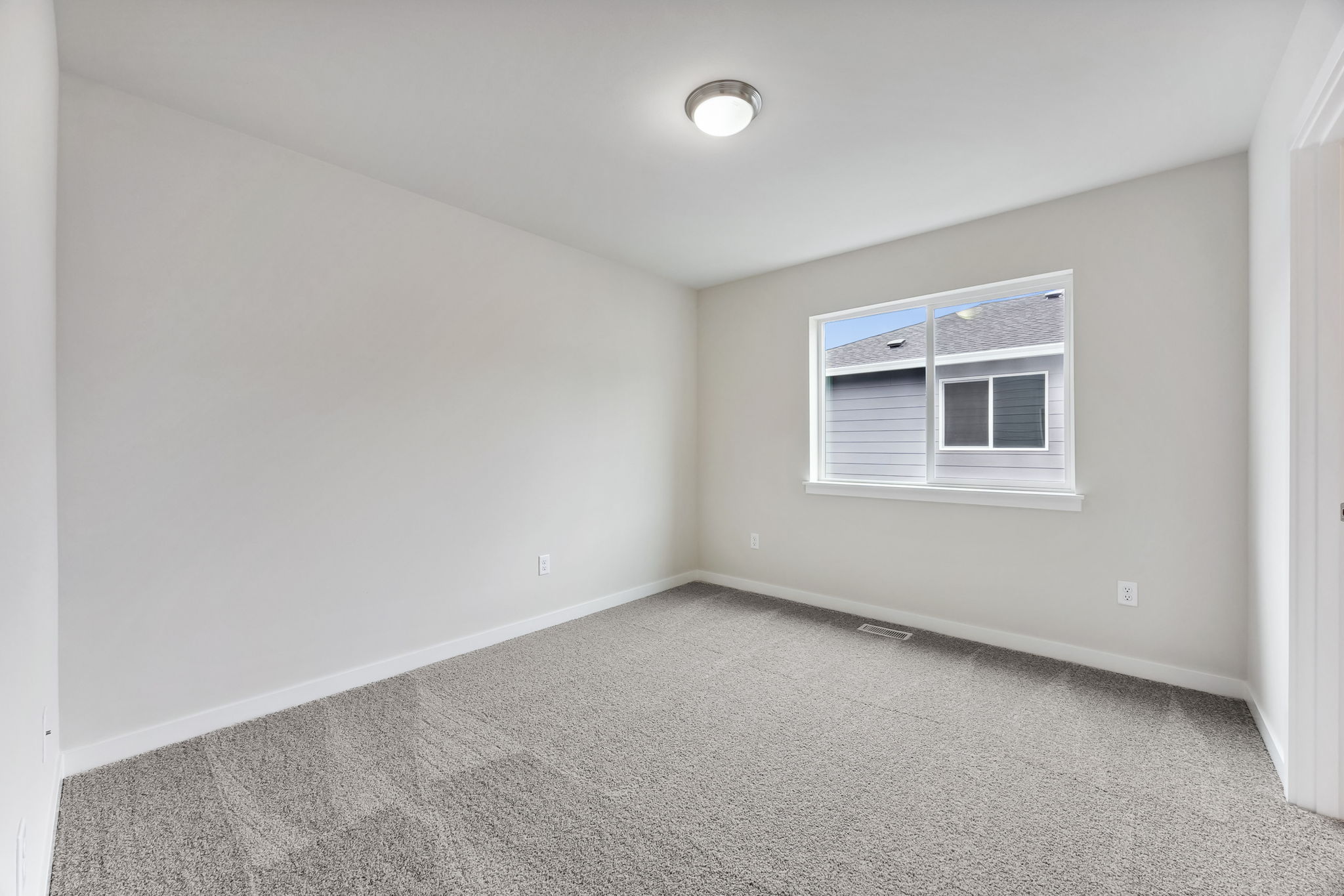 A room with a window and a carpet.