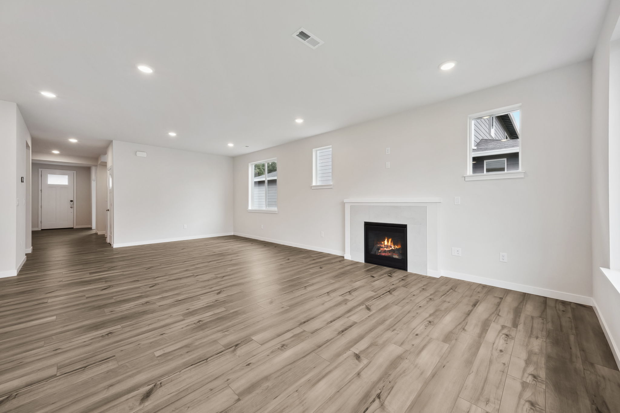 A room with a fireplace and wood floors.