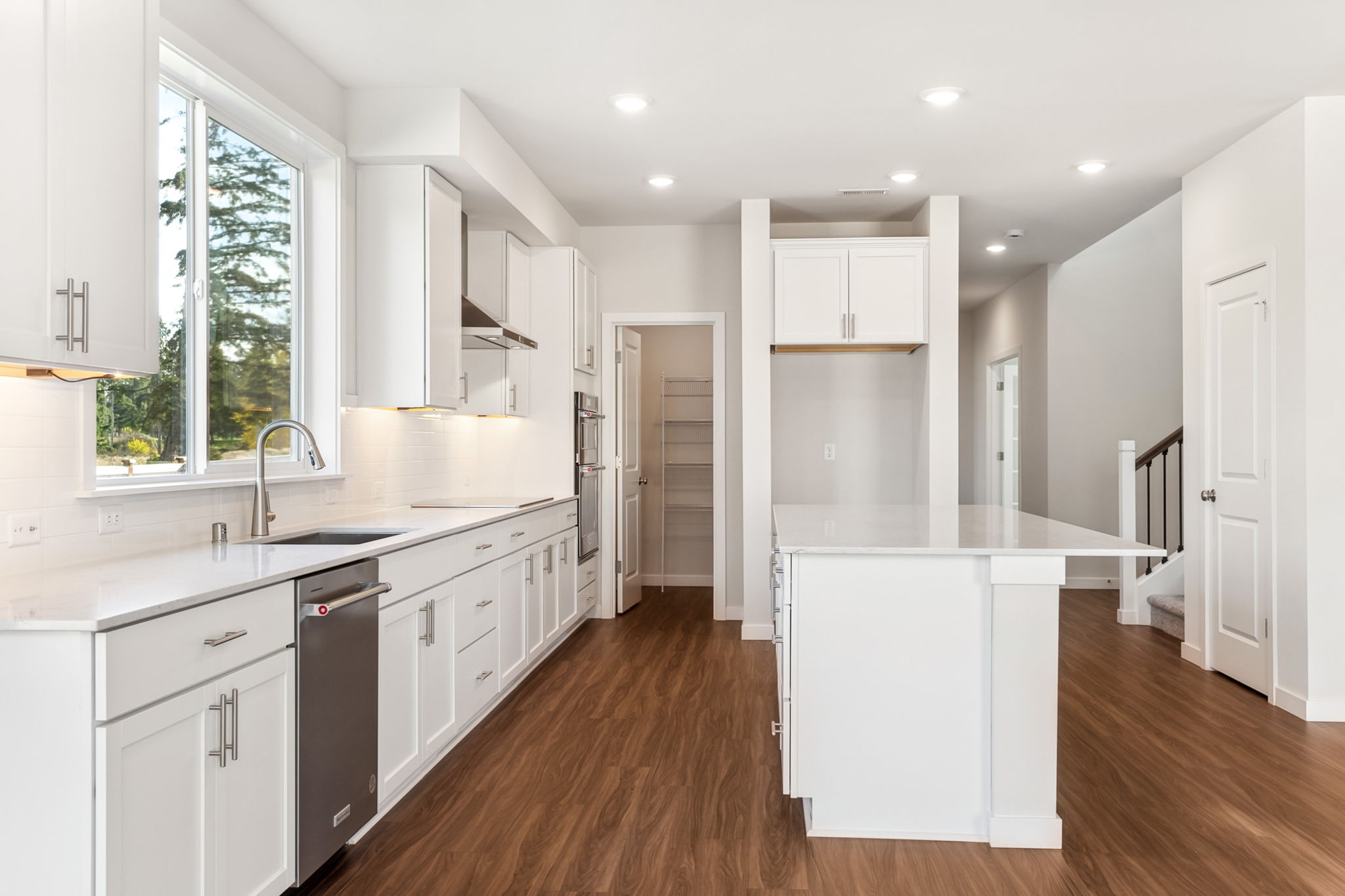 A kitchen with white cabinets.