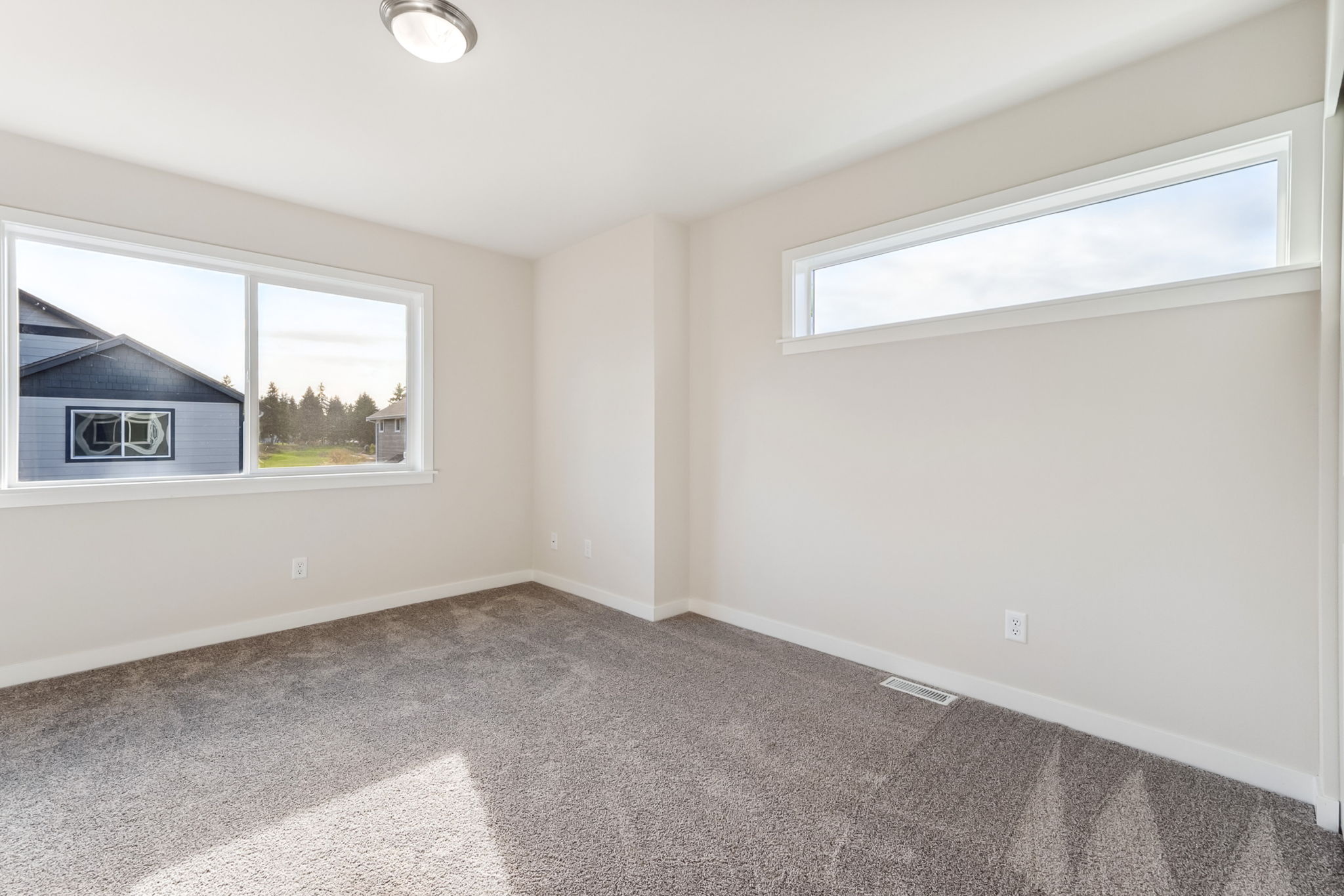 A room with a carpet and windows.