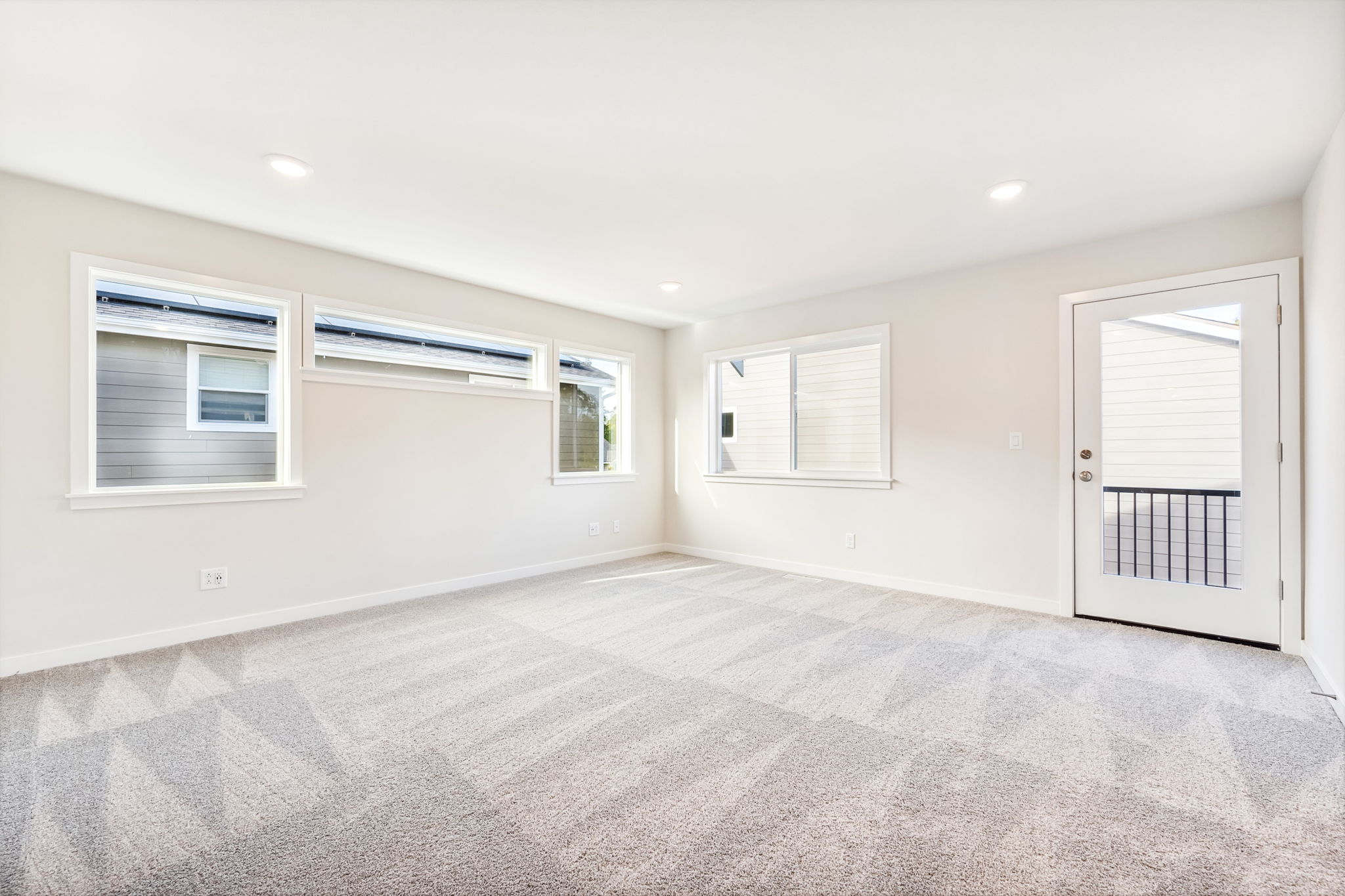 A room with a carpet and windows.