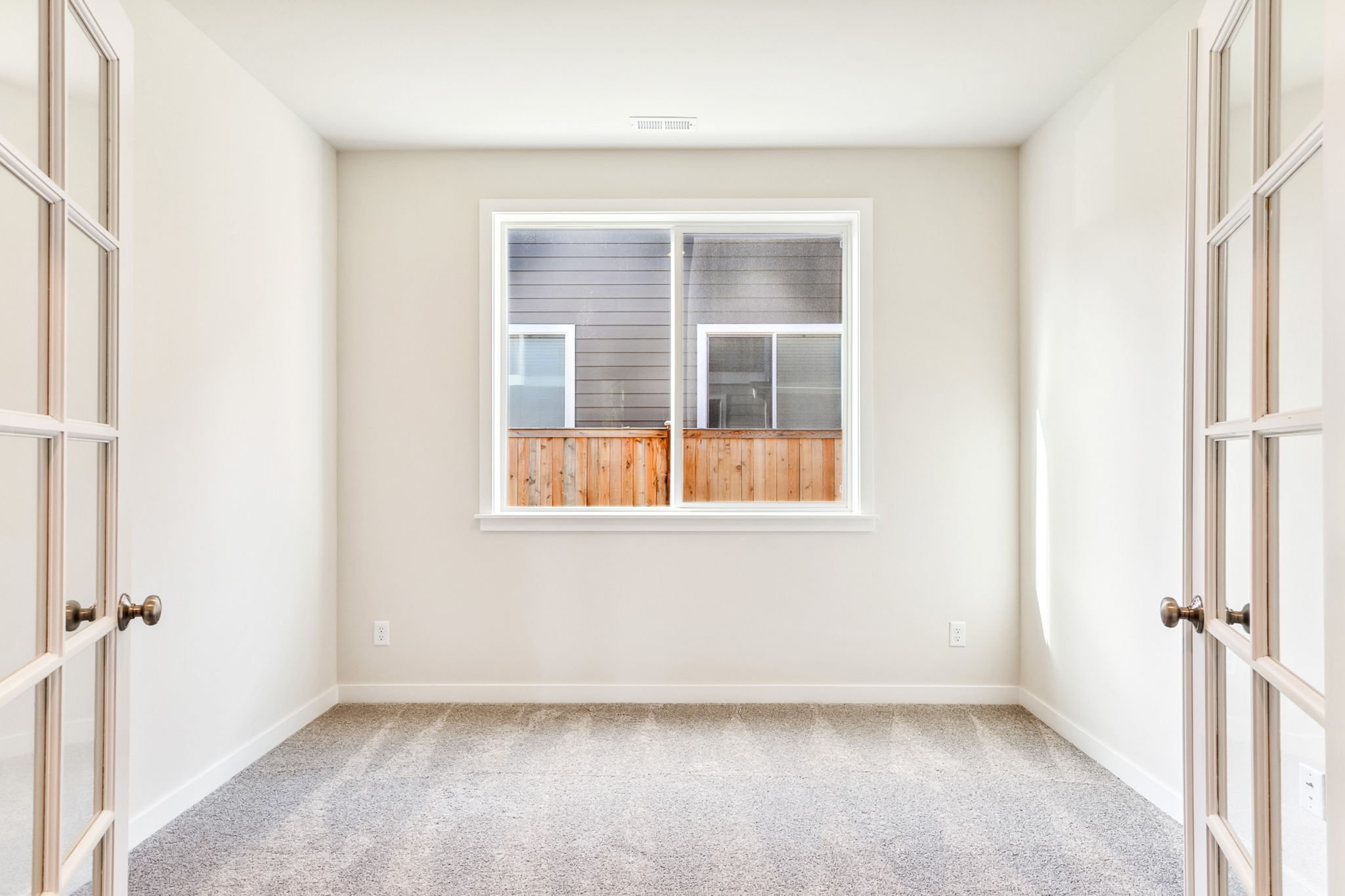 A room with a window and a rug.