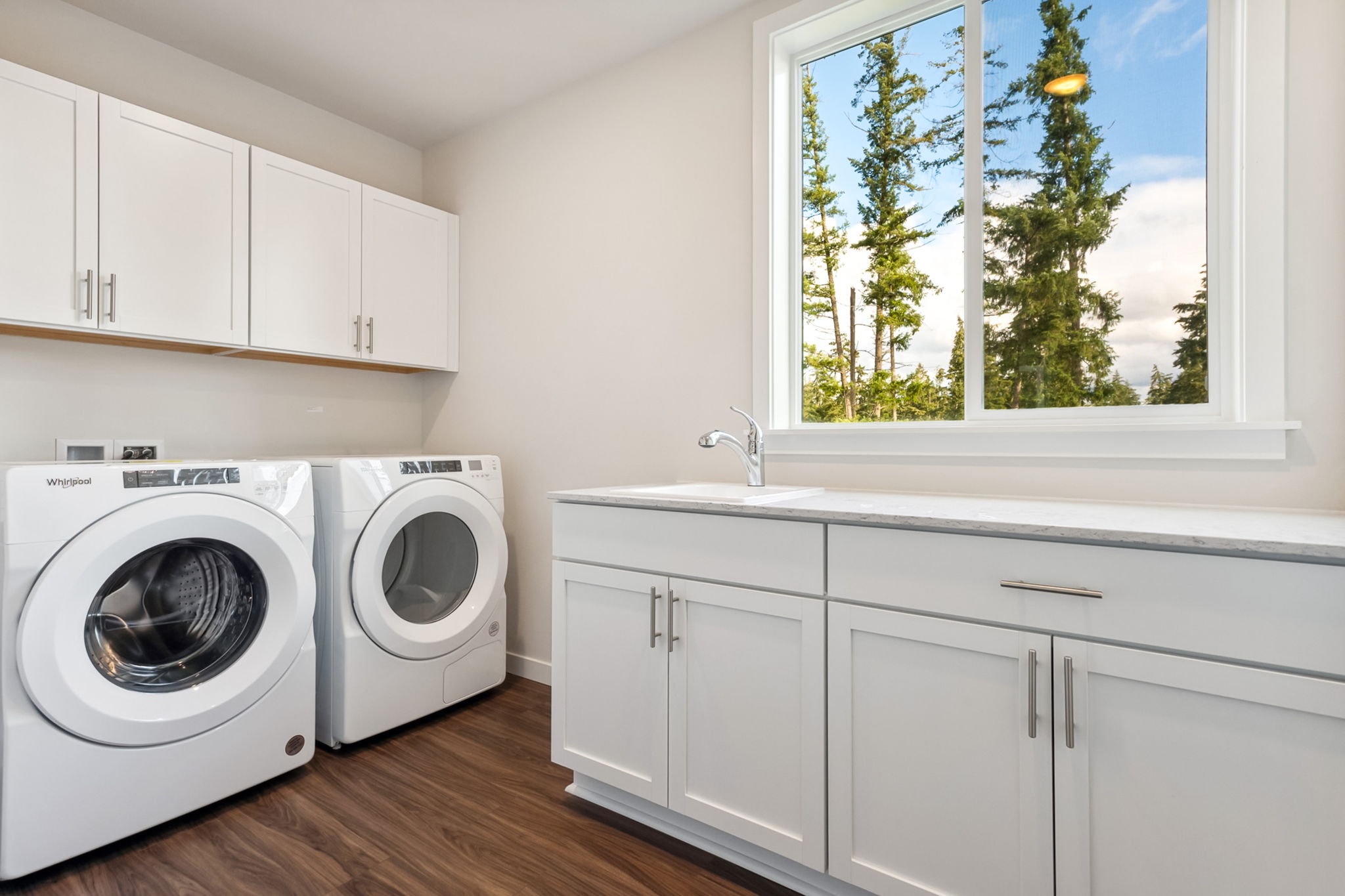 A kitchen with white cabinets.