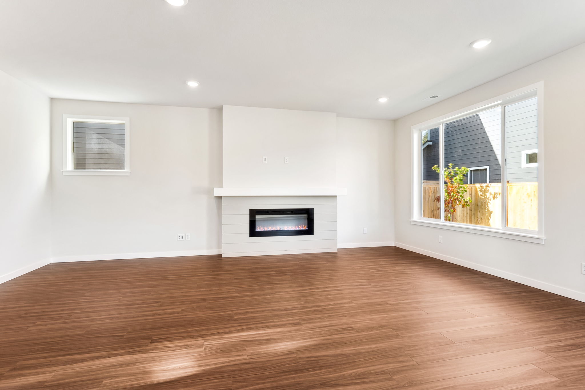 A room with a fireplace and a wood floor.